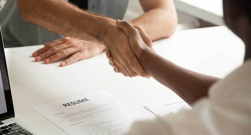 Employment handshake at successful interview between employer and employee. Equal opportunity employer encouraging male, female, veteran and disabled candidates.